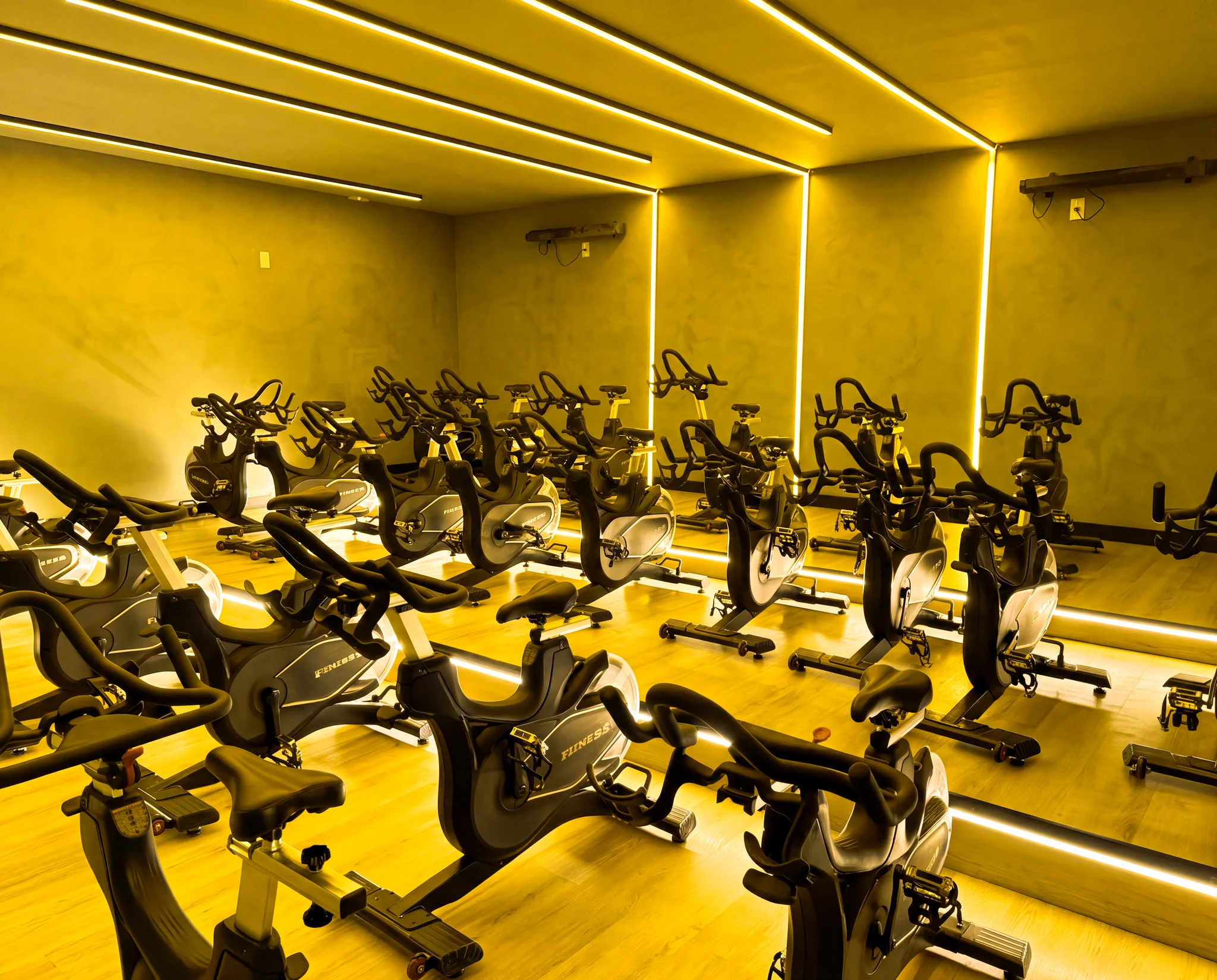 Sala de spinning com bikes e iluminação cênica